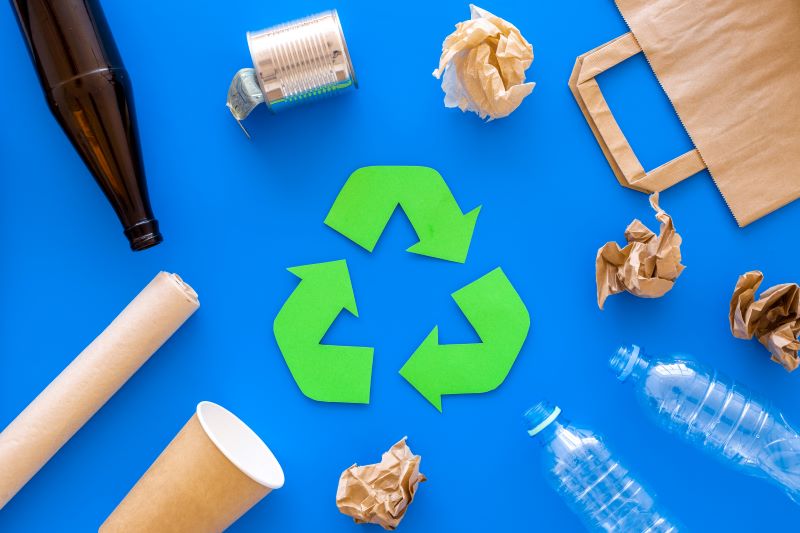 Diferentes tipos de envases junto al símbolo del reciclaje